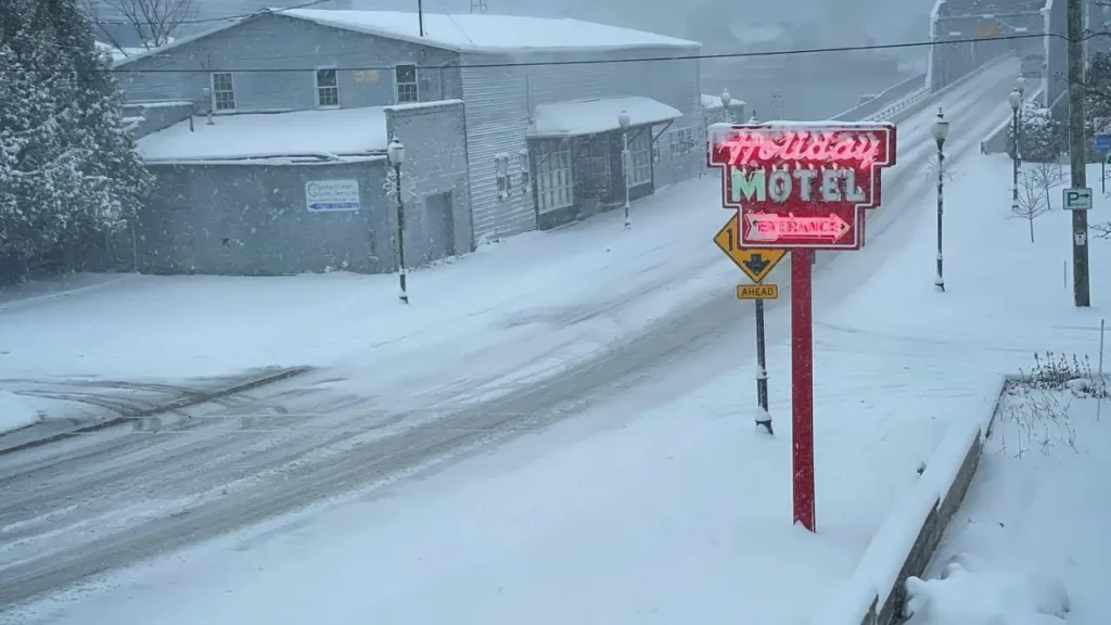 Snowy road with iconic Holiday Music Motel neon sign